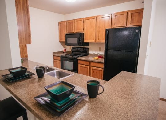 a kitchen with black appliances and granite counter tops