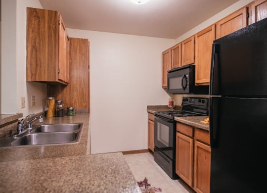 a kitchen with black appliances and granite counter tops