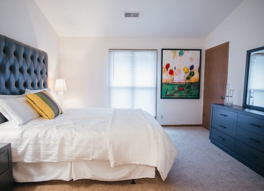 a bedroom with a large bed and a painting on the wall