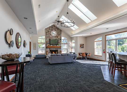 Clubhouse with a grey couch and a fireplace.