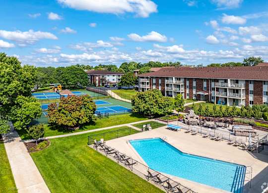 A large swimming pool surrounded by a grassy area and trees.