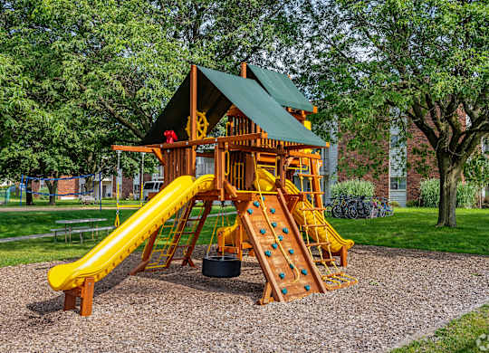 A wooden playground structure with a yellow slide.
