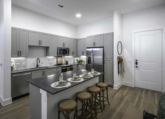 a kitchen with a large island with four stools