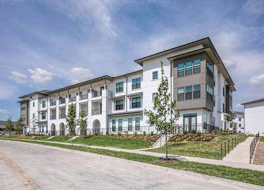 exterior of apartment building with white exterior and gray roof