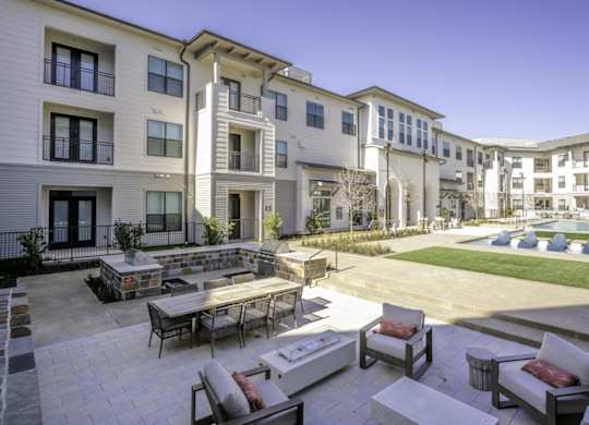 a group of apartments with a courtyard with tables and chairs