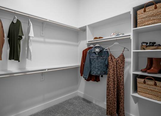 a walk in closet with white walls and built-in shelves