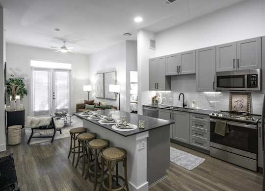 a kitchen and living room with a large island with stools