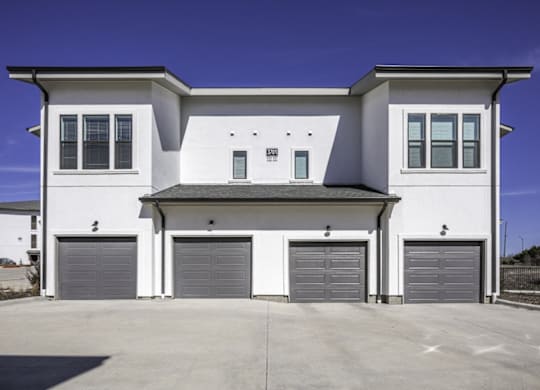 a white house with three garage doors
