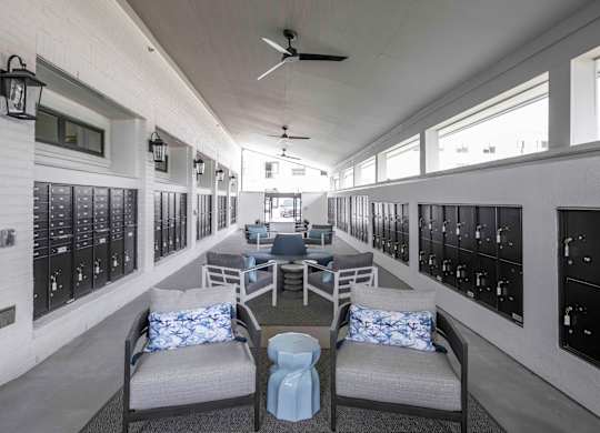 a lounge area with chairs and couches next to the mail lockers