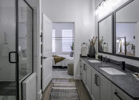 a bathroom with a sink and a shower and a mirror
