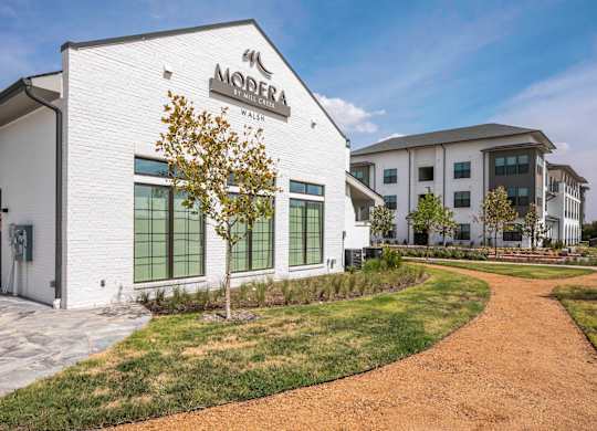 a white clubhouse building with a community signage