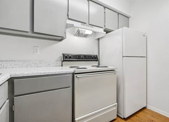 A kitchen with a white refrigerator and a stove top oven.