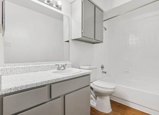 A white bathroom with a toilet, sink, and bathtub.