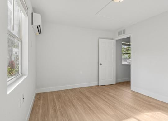 A room with a window, a door, and a ceiling fan.