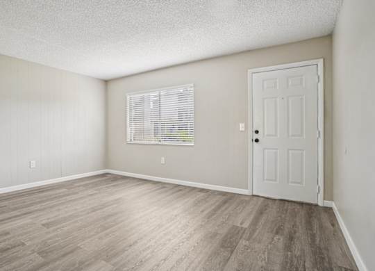 A room with a white door and a window with blinds.