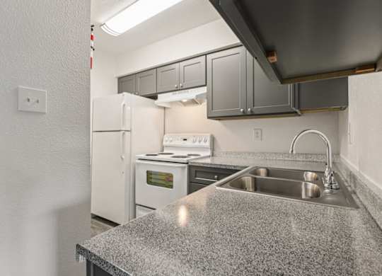 A kitchen with a granite countertop and stainless steel appliances.