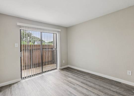 A room with a sliding door leading to a backyard.