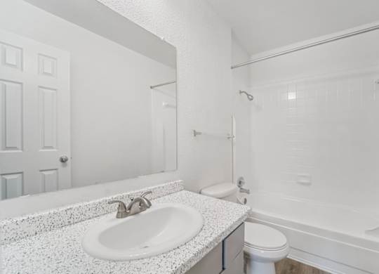 A white bathroom with a sink, toilet, and bathtub.