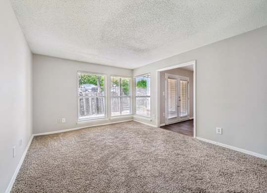 A room with carpeted floor and a door leading to another room.