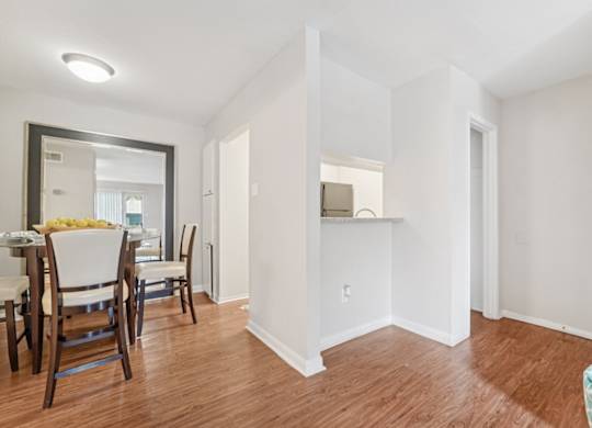 A dining room with a table and chairs.