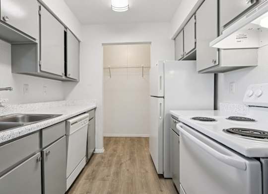 A kitchen with white appliances and cabinets.