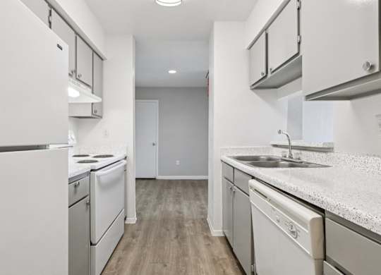 A kitchen with white appliances and cabinets.
