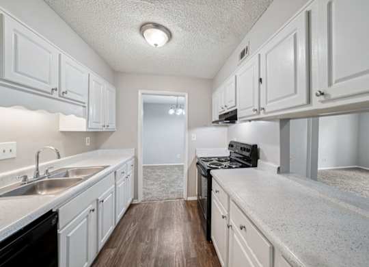 A kitchen with white cabinets and a black dishwasher.