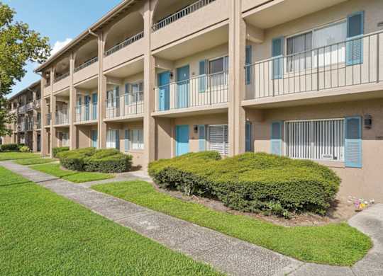 Apartment complex with green bushes in front.