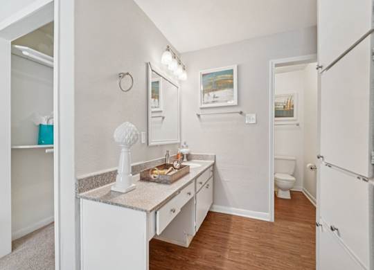 A small white bathroom with a sink, toilet, and a mirror.