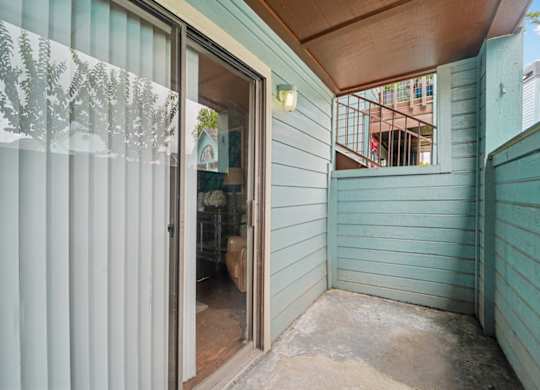 A room with a sliding glass door leading to a balcony.