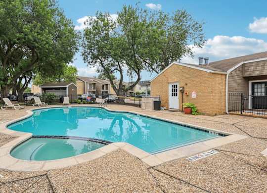 A small pool surrounded by a stone patio.