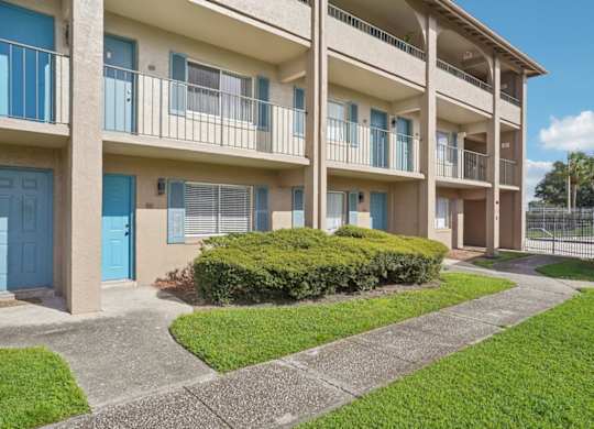 A row of apartment buildings with blue doors and windows.