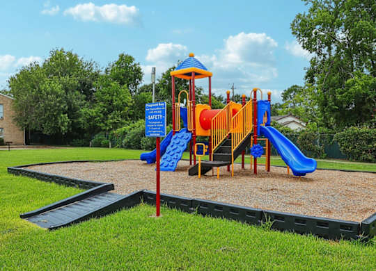 A playground with a blue slide and a yellow slide.