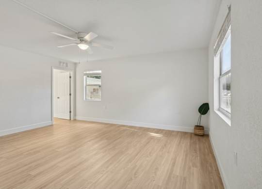A room with a wooden floor and a ceiling fan.