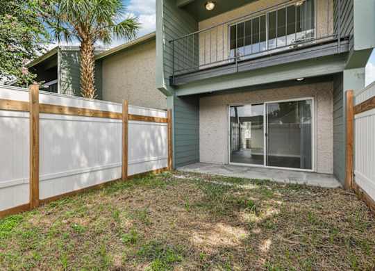 A house with a green exterior and a white fence.
