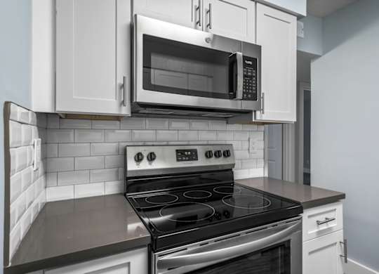 a kitchen with a stove and a microwave at Ascot Place Apartments, Birmingham, AL