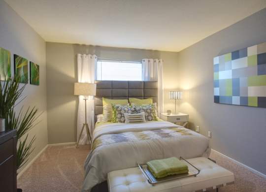 a bedroom with plush carpeting, a window, neutral paint, and model furnishings