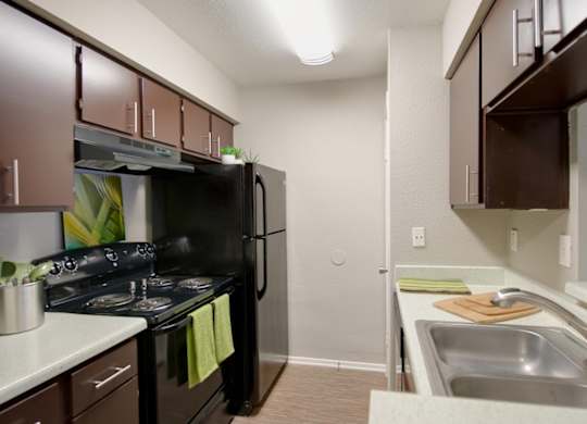 A crosby at westchase kitchen with black appliances and dark wood cabinets