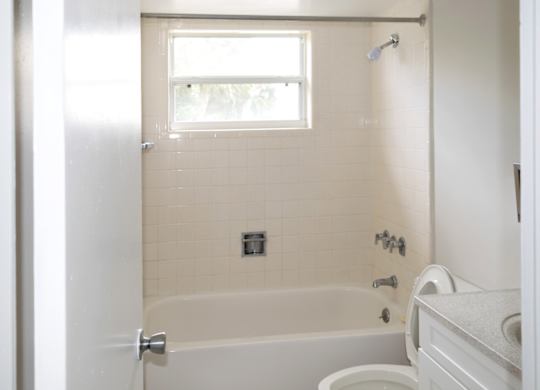 A white bathroom with a tub, toilet, and sink.