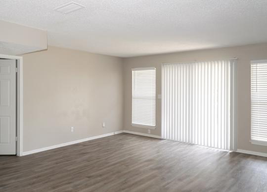 an empty living room with wood flooring and white walls