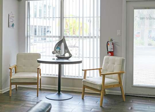 a living room with two chairs and a table and a window