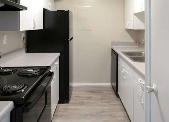 a kitchen with black appliances and white cabinets