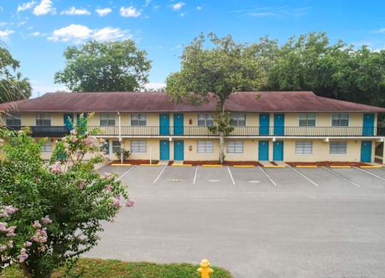 Ridge Apartments residential building exterior with a large parking lot surrounded by trees