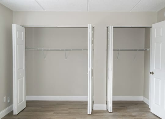 a Ridge Apartments bedroom with two large closets with hanging bars