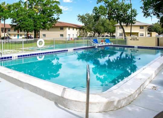 a blue swimming pool and a sundeck with loungers at Ridge Apartments