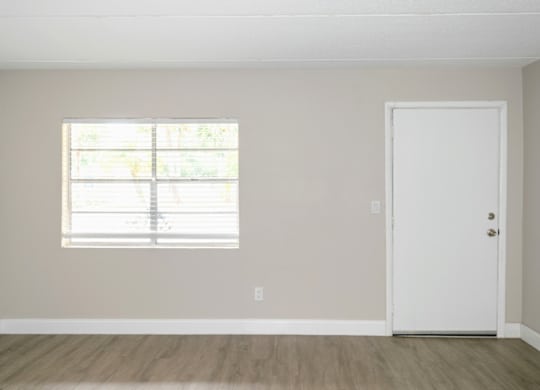 a spacious living room with a large window in a Ridge Apartment home