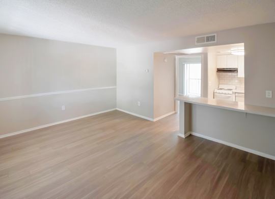 an spacious living room and kitchen with wood flooring at Waterview Crossing Apartments