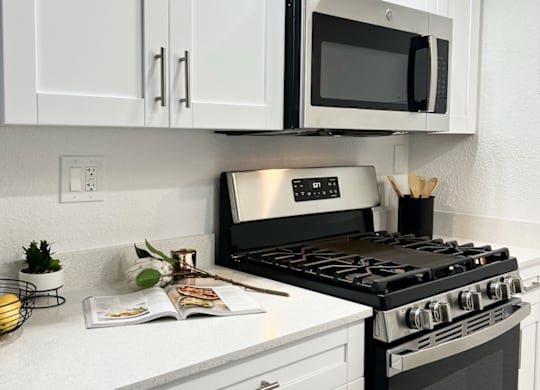 a modern kitchen with stainless steel appliances, a gas stove, and quartz countertops