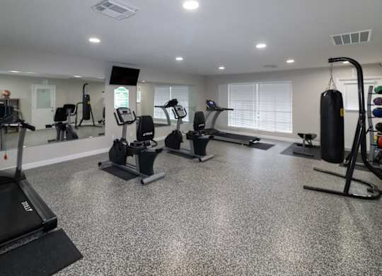 a gym with treadmills and other exercise equipment in the new Forest Apartments Fitness Center