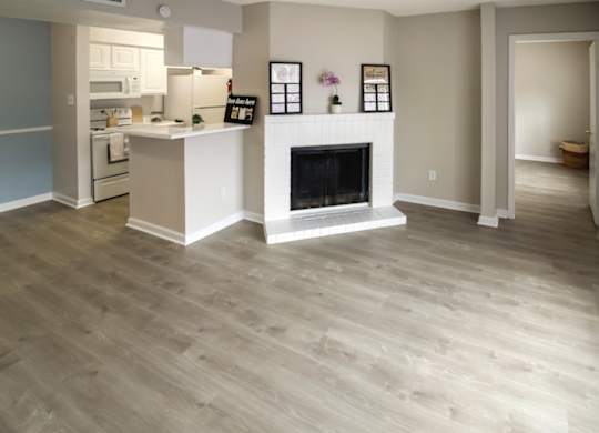 an apartment interior with a fireplace, kitchen, and wood-style floors at Pine Creek